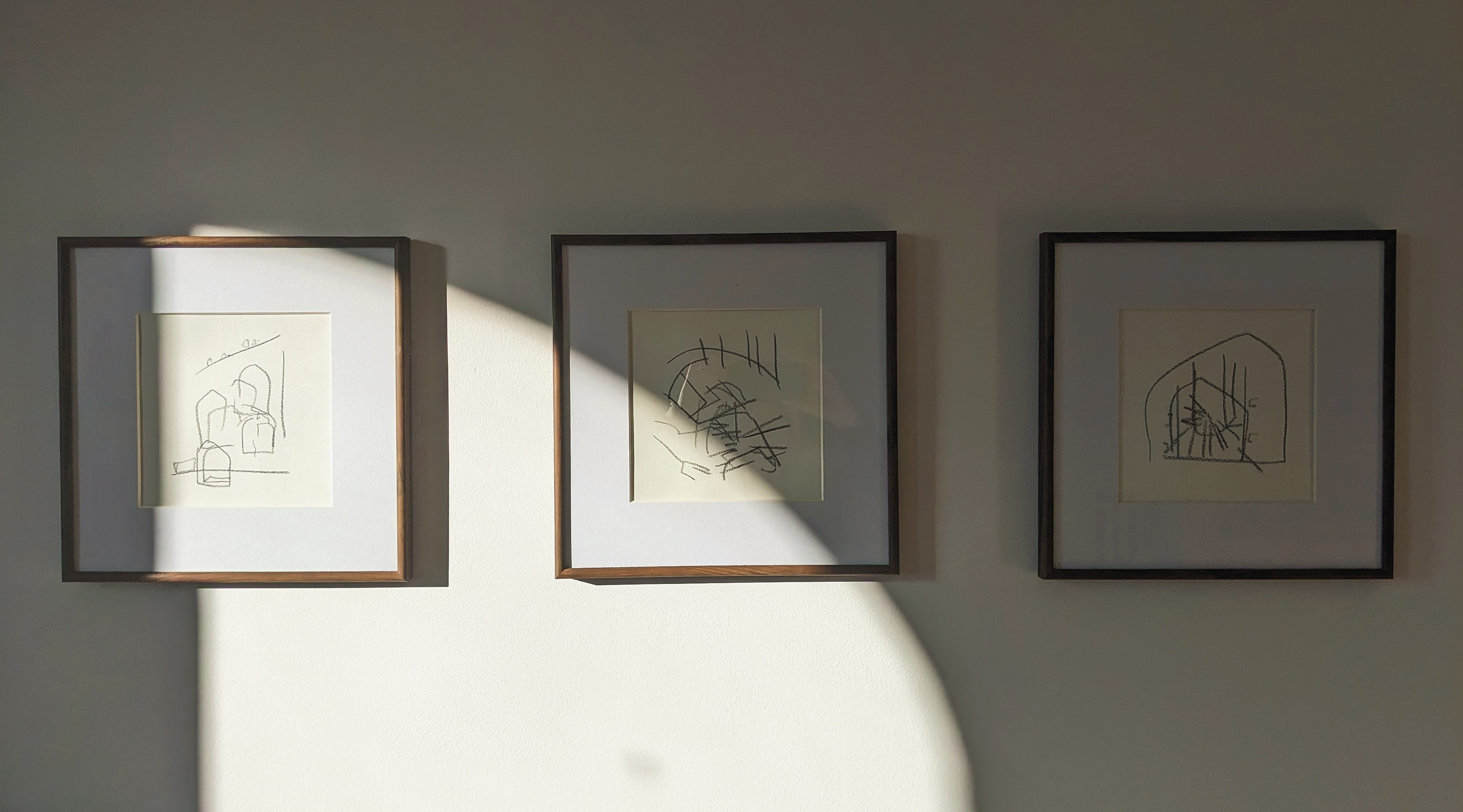A photograph of three separate black and white abstract line drawings.